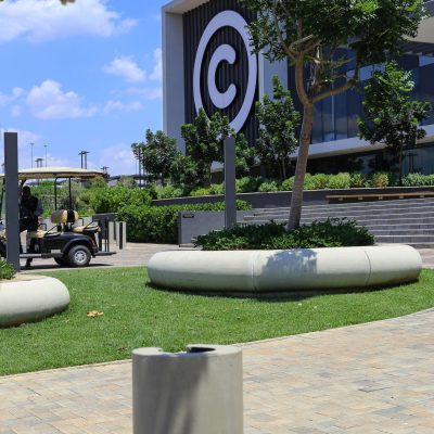 Gallo Precast Bollard and Planters view of the landscaped courtyard and paved walkways at the Cell C Building in Midrand, featuring trees, seating areas, and access roads.